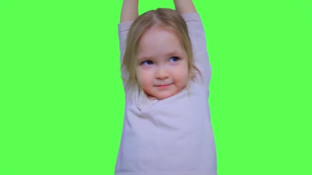 Χαριτωμένο κοριτσάκι που κρέμεται από τα χέρια σε πράσινη οθόνη φόντου — Αρχείο Βίντεο