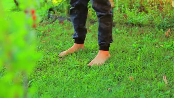 Barfußbeine eines unbekannten Mannes in Militärhosen auf dem Rasen — Stockvideo