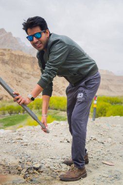 Leh ladakh bölgesinde el pompasıyla su pompalayan susuz Hintli turist