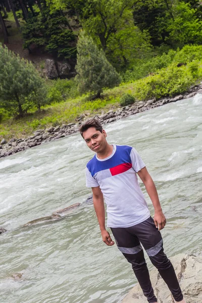 Joven hombre asiático turista en bosque de montaña en la orilla del río — Foto de Stock