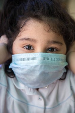 Kendilerini virüsten ve hava kirliliğinden korumak için maske takan Hintli küçük kıza yaklaş. Coronavirus covid-19 salgınının insandan insana yayılmasını engellemek için maske ile önleme.
