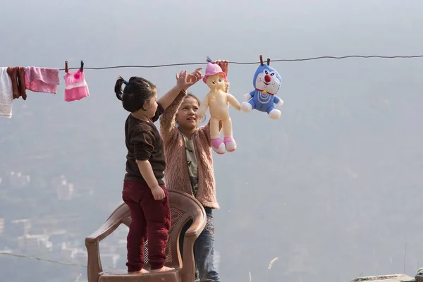 Çamaşırhane yapıyor ve açık havada oynayan çocuklar.