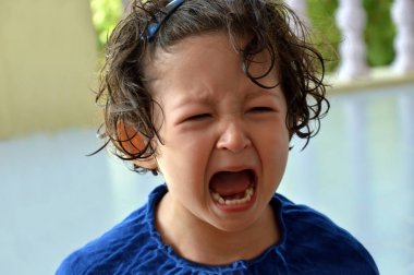 Ağız geniş açık ve üzgün ifade karşısında ile ağlayan bir kız yürümeye başlayan çocuk portresi.