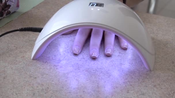 Uñas de secado en la máquina de secado de uñas de lámpara UV . — Vídeos de Stock