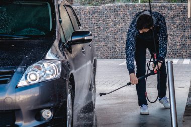 Adam Coronavirus sırasında arabayı kendisi yıkar.