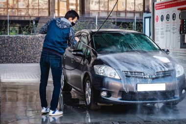 Adam Coronavirus sırasında arabayı kendisi yıkar.