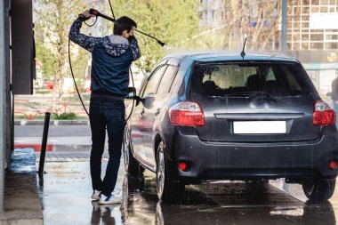 Adam Coronavirus sırasında arabayı kendisi yıkar.