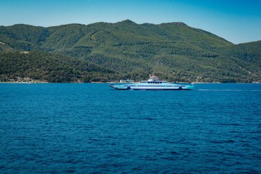Tropik bir adanın yakınındaki körfezde beyaz yatlar ve katamaranlar. Deniz yatı ve motorlu katamaran kiralamak için ve göl kenarındaki baregoon için. Mavi deniz, okyanus gezisi sırasında beyaz gemiler.