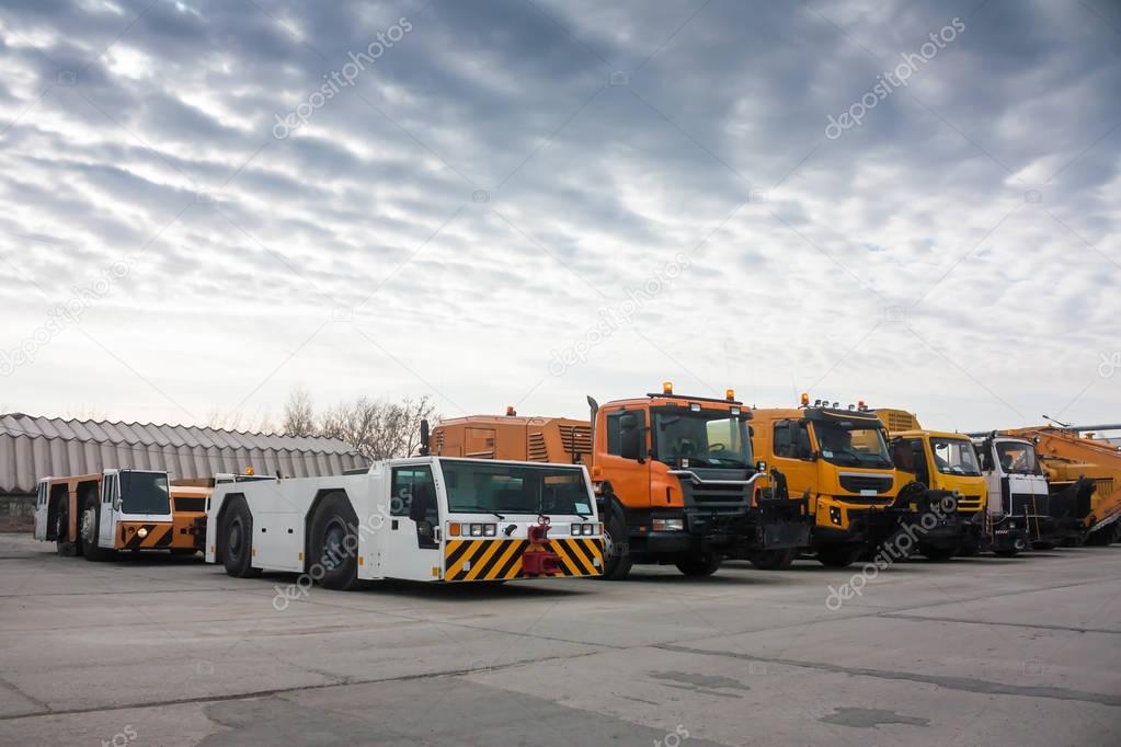 Tow tractors and cleaning trucks in the airport