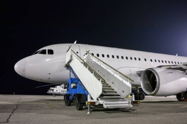 Uçak ve yolcu adımları araç gece Havaalanı önlük, yatılı
