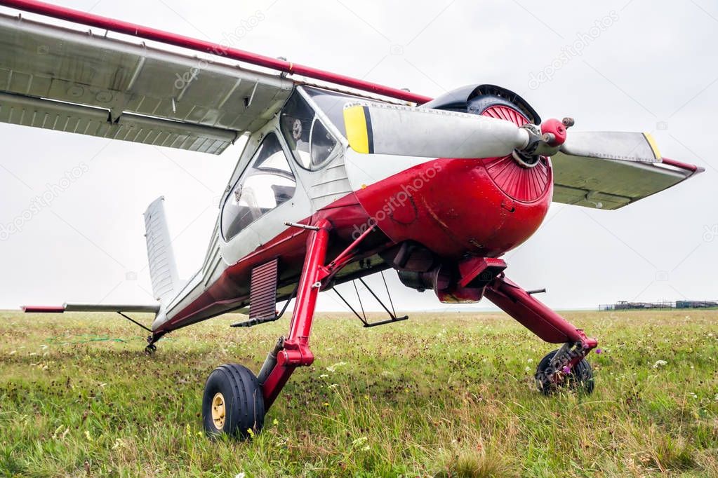 Small sports airplane for towing gliders stands on the grass