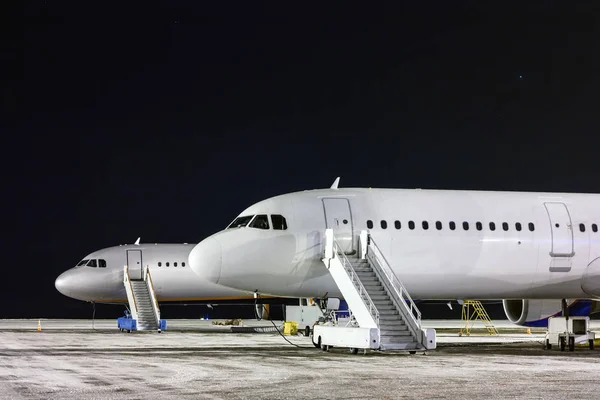 Przedniej Części Dwóch Samolotów Wejściem Schodach Nocy Zimowych Lotnisko Fartuch — Zdjęcie stockowe