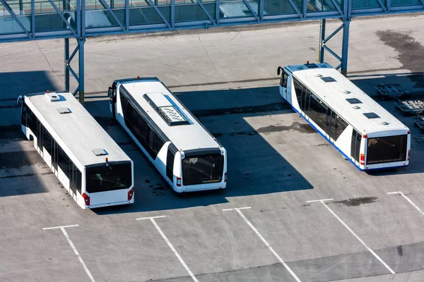 Airport buses at the parking near passenger boarding bridge