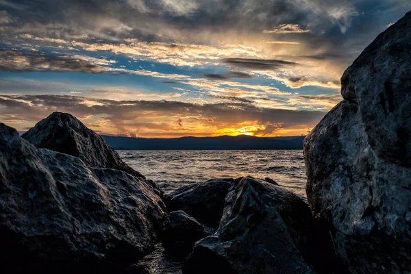 在湖岸边的大石块在美丽的日落的背景下 — 图库照片