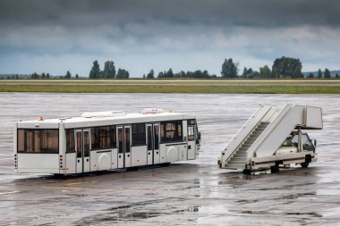 Servis otobüsü ve Havaalanı apron merdiven yağmurlu bir gün yatılı yolcu