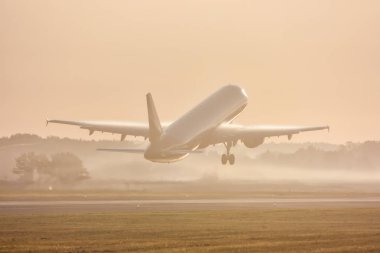 Yolcu uçağı sabah sisinde kalkıyor.