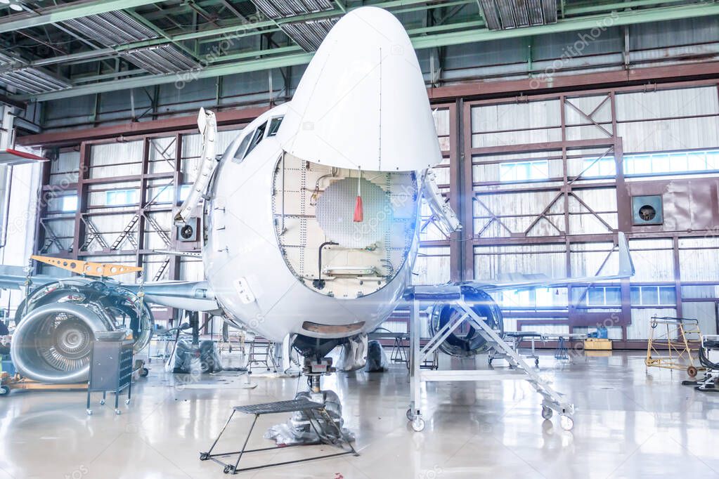 Passenger aircraft under maintenance. Checking mechanical systems of airplane for flight operations. Front view