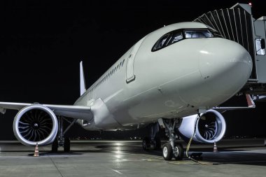 Havaalanı gece uçağında beyaz bir yolcu uçağını yakın plan çekiyoruz.