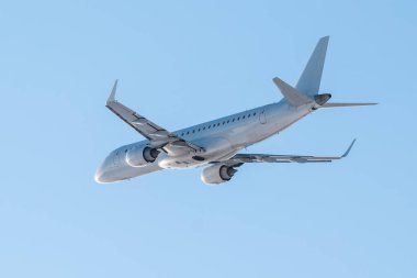 Açık ve güneşli bir günde açık mavi gökyüzüne karşı modern beyaz yolcu uçakları havada uçar.