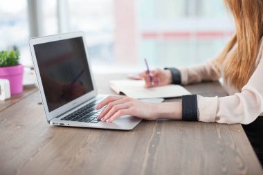 Bilgisayarı, tableti ve telefonu olan bir ofis masası. Dişi eller kalemi tutar. Ofis İşçi Masası