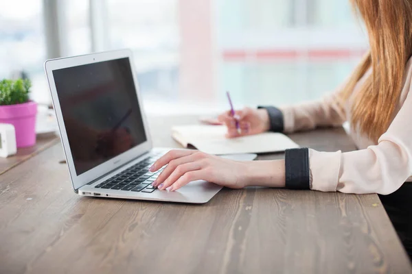 Bilgisayarı, tableti ve telefonu olan bir ofis masası. Dişi eller kalemi tutar. Ofis İşçi Masası