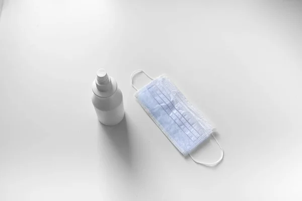 Beyaz arka planda maske ve dezenfektan