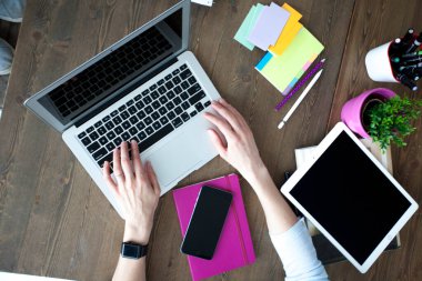Bilgisayarı, tableti ve telefonu olan bir ofis masası. Dişi eller kalemi tutar. Ofis İşçi Masası