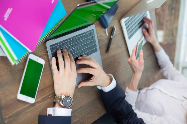 Bilgisayarı, tableti ve telefonu olan bir ofis masası. Erkek eli kalem tutar. Ofis İşçi Masası