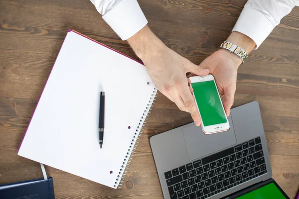 Bilgisayarı, tableti ve telefonu olan bir ofis masası. Erkeklerin elleri akıllı telefon tutuyor. Ofis İşçi Masası