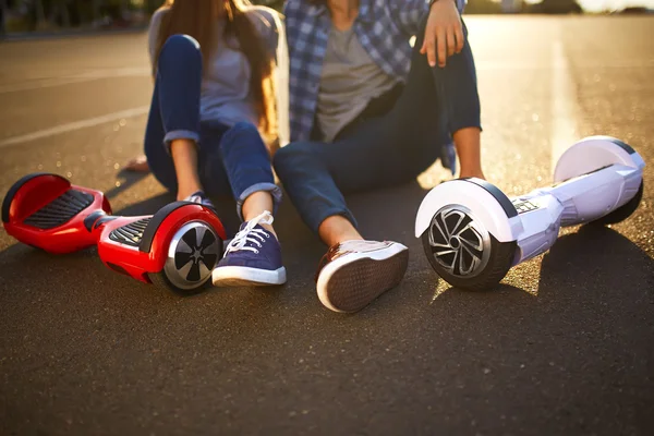 Młody mężczyzna i kobieta jazda na Hoverboard w parku. Deskorolka Smart — Zdjęcie stockowe