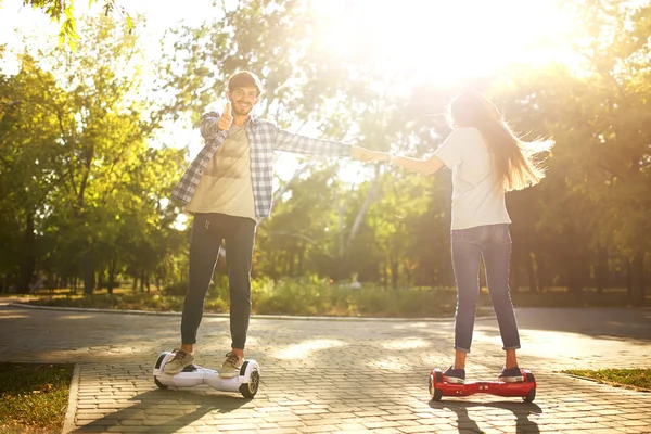 Jeune homme et jeune femme chevauchant le Hoverboard dans le parc. Skateboard Smart — Photo