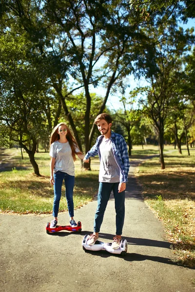 若い男と公園でホバーボードに乗って女。スケート ボード スマート — ストック写真