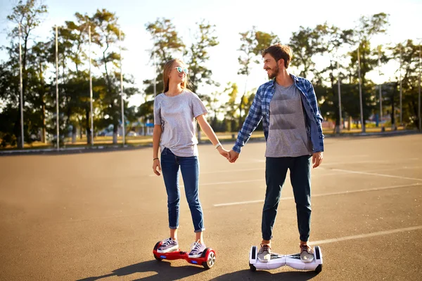 Pria dan wanita muda naik di Hoverboard di taman. Pintar Skateboard Stok Foto Bebas Royalti