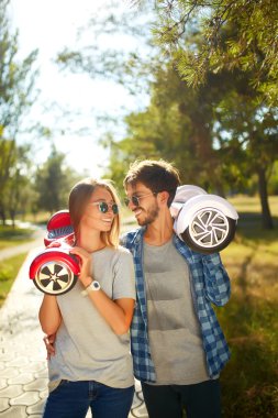 genç adam ve kadın parkta Hoverboard sürme. içerik teknolojileri. yeni bir hareket