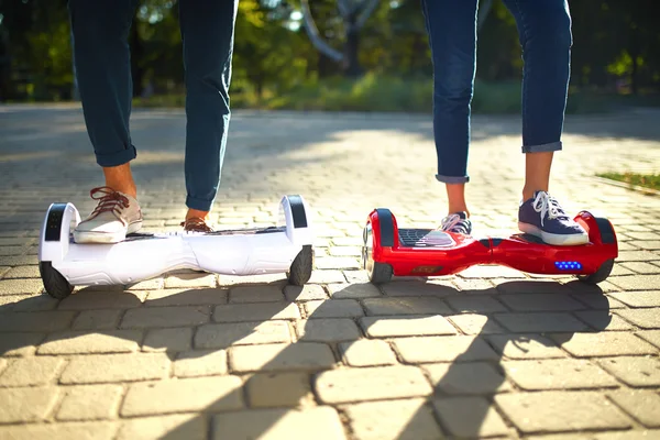 Joven hombre y mujer cabalgando en el Hoverboard en el parque. tecnologías de contenido. un nuevo movimiento — Foto de Stock