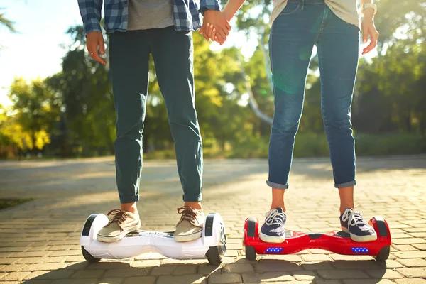 Młody mężczyzna i kobieta jazda na Hoverboard w parku. zawartości technologii. nowy ruch — Zdjęcie stockowe