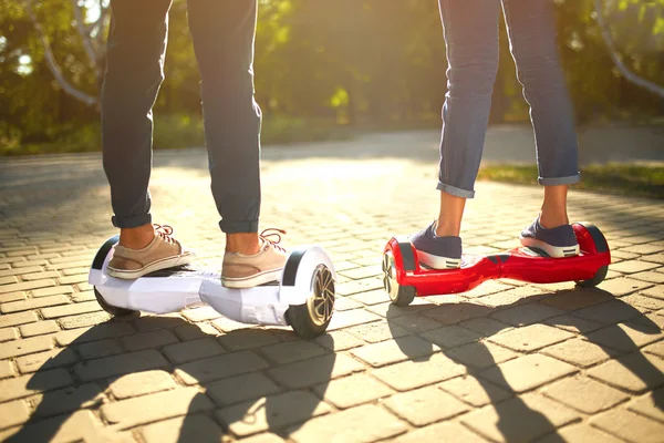 Jeune homme et jeune femme chevauchant le Hoverboard dans le parc. technologies de contenu. un nouveau mouvement — Photo