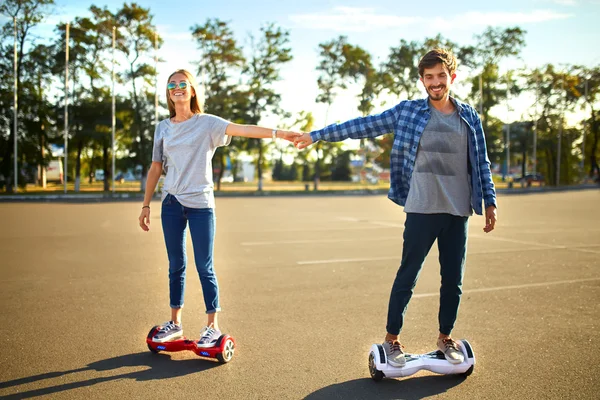 Νεαρός άνδρας και γυναίκα, ιππασία, σχετικά με το Hoverboard στο πάρκο. περιεχομένου τεχνολογίες. ένα νέο κίνημα — Φωτογραφία Αρχείου