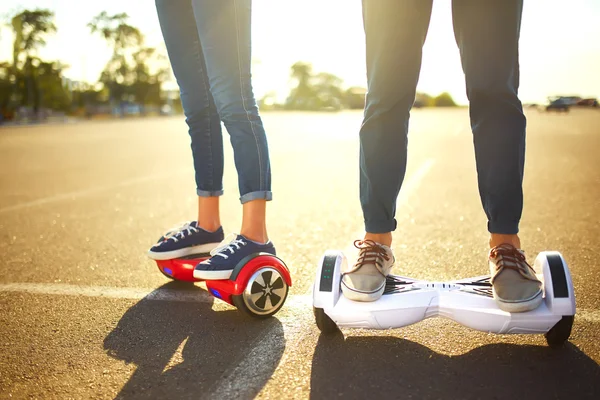 Jeune homme et jeune femme chevauchant le Hoverboard dans le parc. technologies de contenu. un nouveau mouvement — Photo