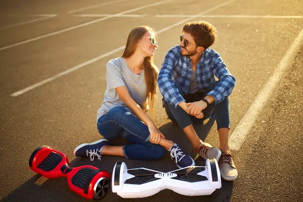 Ung man och kvinna rider på Hoverboard i parken. innehåll teknik. en ny rörelse — Stockfoto