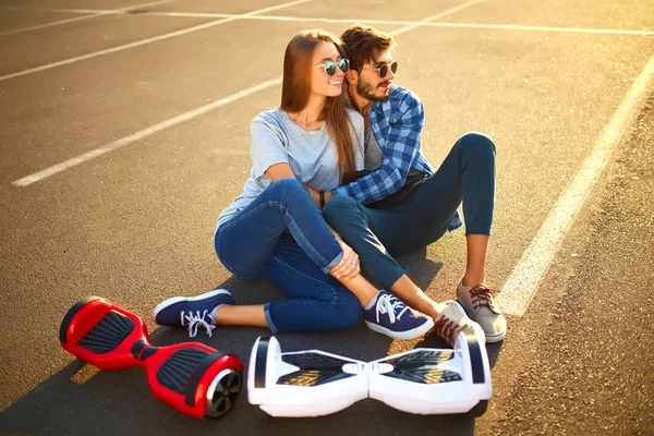 Ung man och kvinna rider på Hoverboard i parken. innehåll teknik. en ny rörelse — Stockfoto