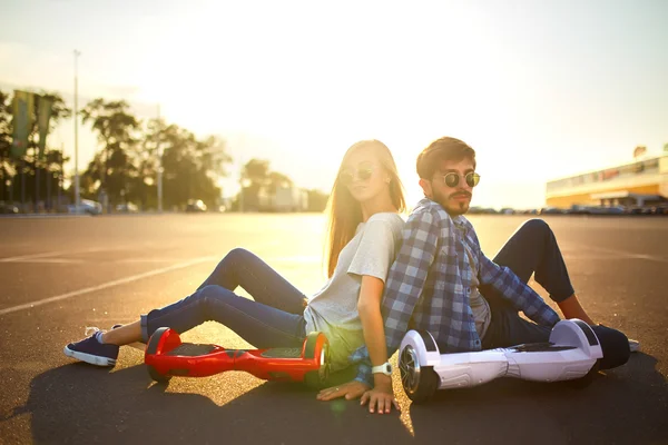 genç adam ve kadın parkta Hoverboard sürme. içerik teknolojileri. yeni bir hareket