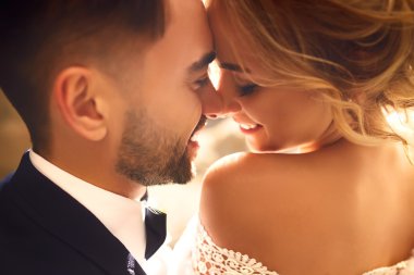 Gelin ve damat şefkatle uçan bir peçe güzel resimler gölgesinde öper. çocuklar keyfini çıkarın. Aşıkların seksi öpüşme şık çift portre kadar kapatın