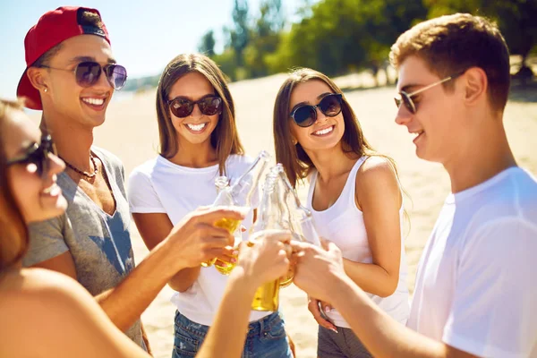 Groep vrienden opknoping met bier op het strand. Uitstekende zonnig weer. Mooie cijfers. Zomer concept — Stockfoto
