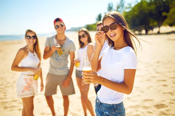 Groupe d'amis traînant avec de la bière à la plage. Très beau temps ensoleillé. Belles chiffres.Concept d'été — Photo