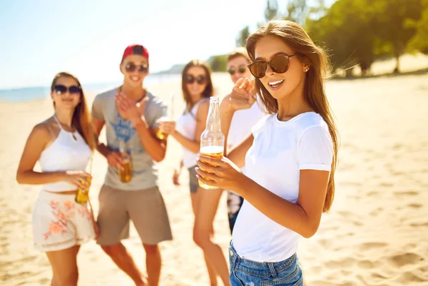 Groupe d'amis traînant avec de la bière à la plage. Très beau temps ensoleillé. Belles chiffres.Concept d'été — Photo