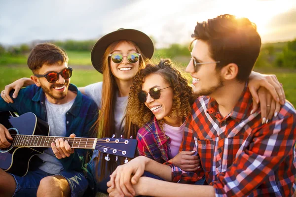 Grup arkadaşıyla birlikte eğleniyor. Adam gitar çalıyor. Herkes büyük bir ruh var.