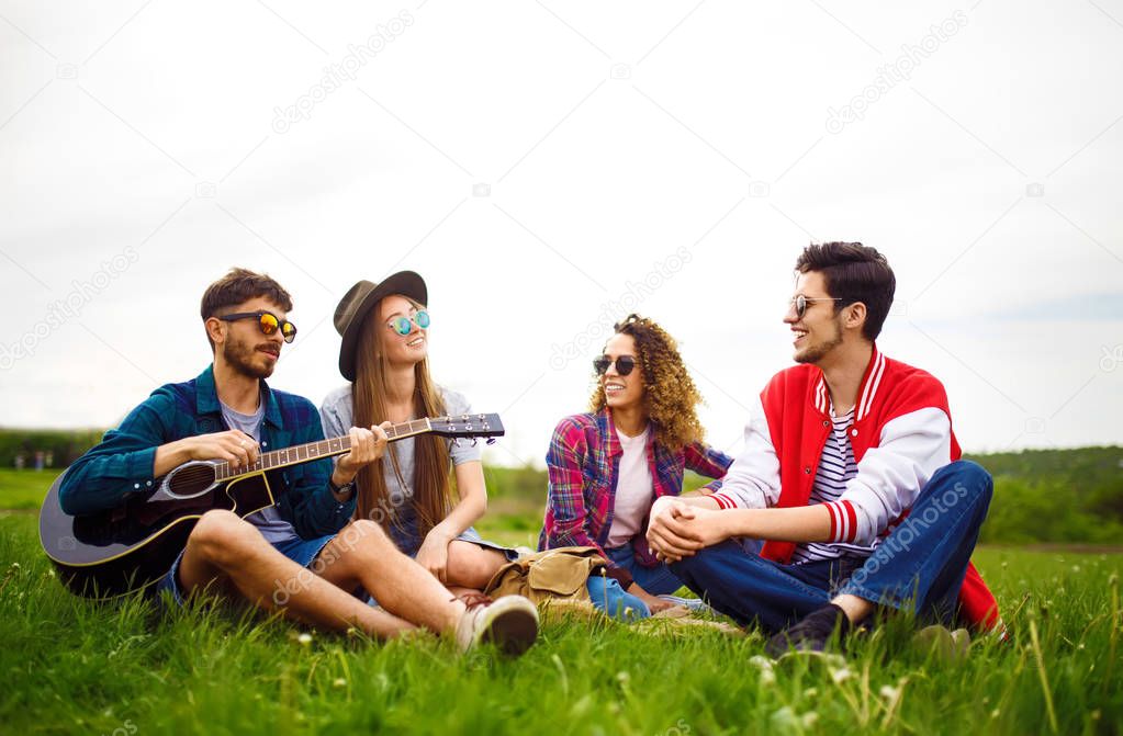 Group of friends enjoying party. The guy plays the guitar. Everyone has a great mood.