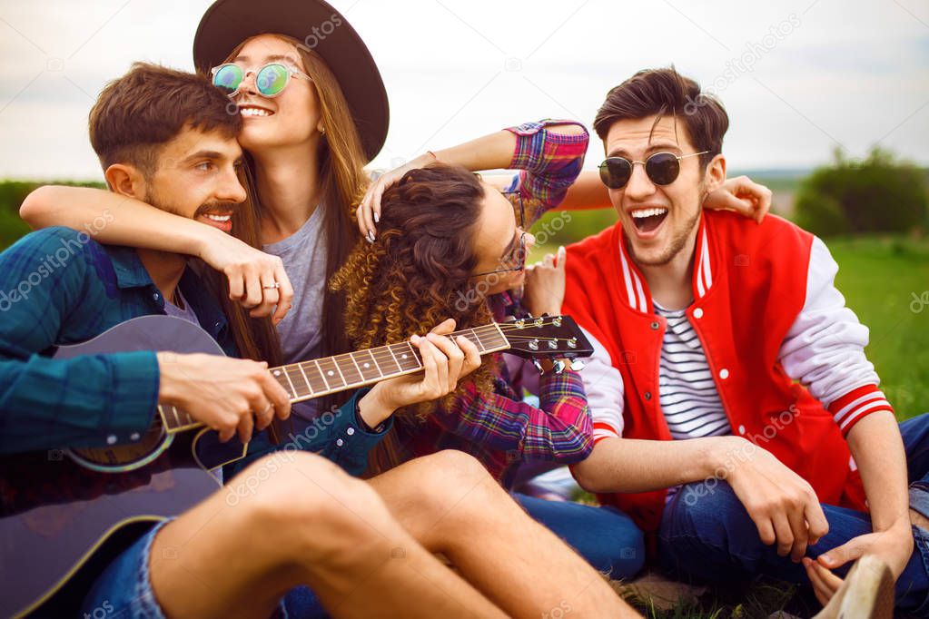 Group of friends enjoying party. The guy plays the guitar. Everyone has a great mood.