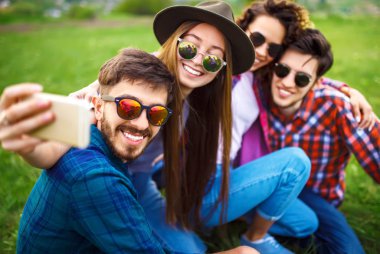 Grup arkadaşıyla birlikte eğleniyor. Adam gitar çalıyor. Herkes büyük bir ruh var.